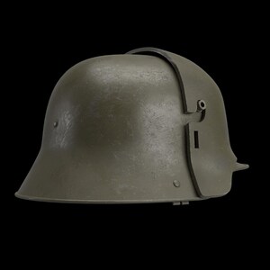 May include: An olive-green military helmet with a curved brim and a leather strap across the top. The helmet has a textured surface and a side plate with a small opening. The helmet is set against a black background.