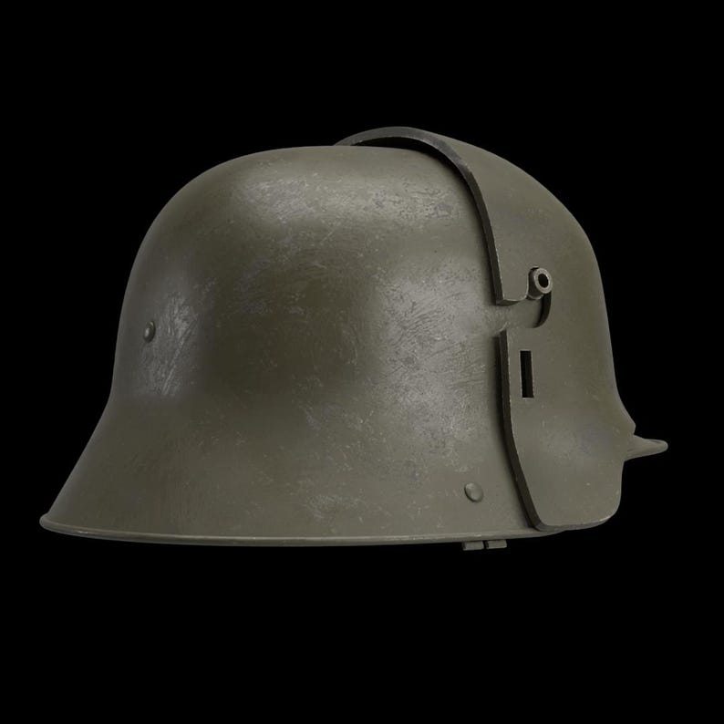 May include: An olive-green military helmet with a curved brim and a leather strap across the top. The helmet has a textured surface and a side plate with a small opening. The helmet is set against a black background.
