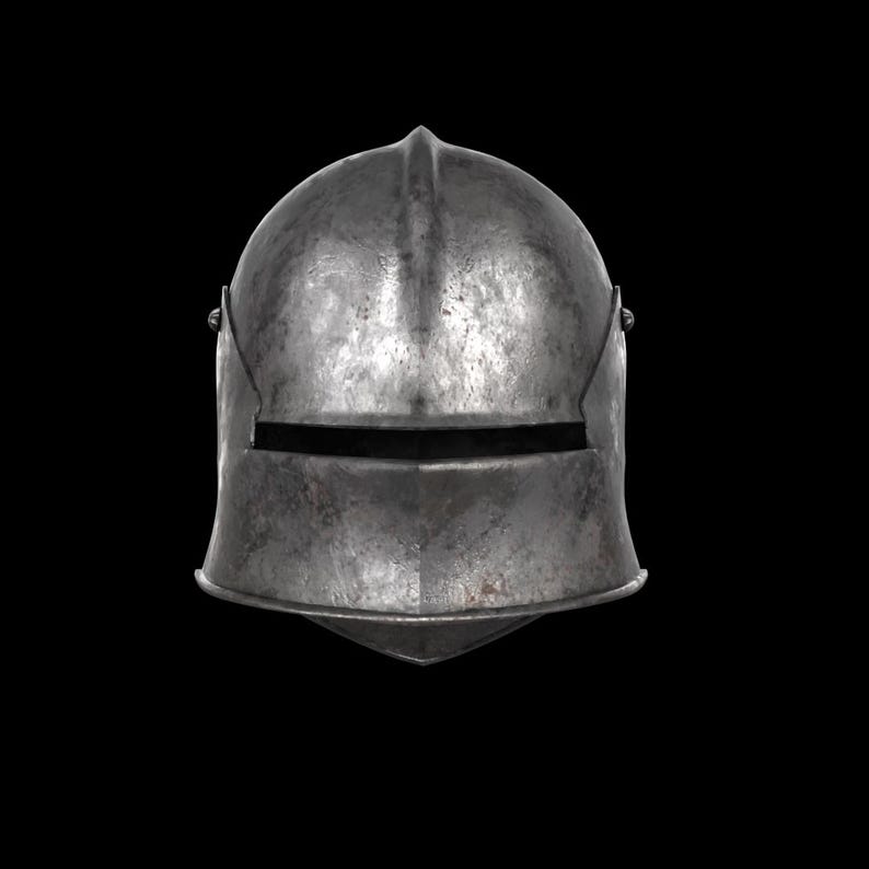May include: A weathered, metallic helmet with a pointed top and a horizontal eye slit. The helmet's surface shows signs of wear and tear, suggesting age and use. The design is simple and functional, typical of historical armor.