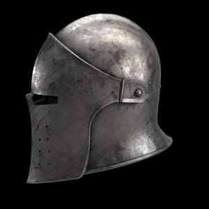 May include: A weathered, metallic helmet with a visor and a rounded top. The helmet has a dark, aged appearance, suggesting historical use. The visor features a horizontal eye slit and several small ventilation holes.