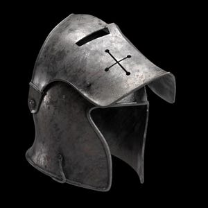 May include: A weathered, metallic helmet with a visor and a cross-shaped design. The helmet has a dark, aged appearance, suggesting historical use. The visor features a horizontal slit for vision. The overall design evokes medieval armor.