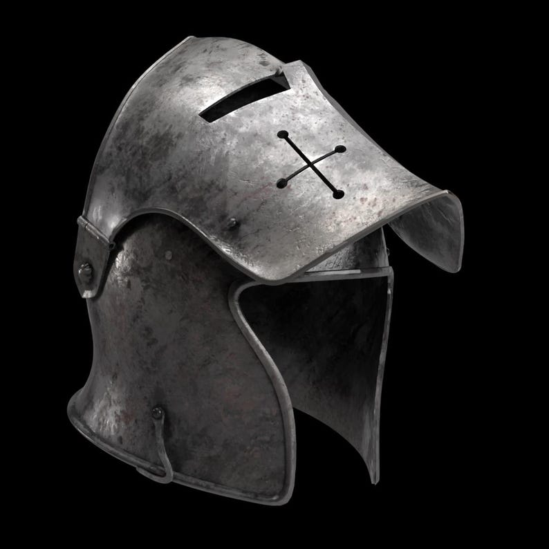 May include: A weathered, metallic helmet with a visor and a cross-shaped design. The helmet has a dark, aged appearance, suggesting historical use. The visor features a horizontal slit for vision. The overall design evokes medieval armor.