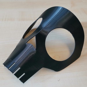 K&ouml;nnte beinhalten: Eine schwarze Plastik-Sch&auml;delmaske mit Augen- und Mundaussparungen. Die Maske ist so konzipiert, dass sie Augen und Nase bedeckt.