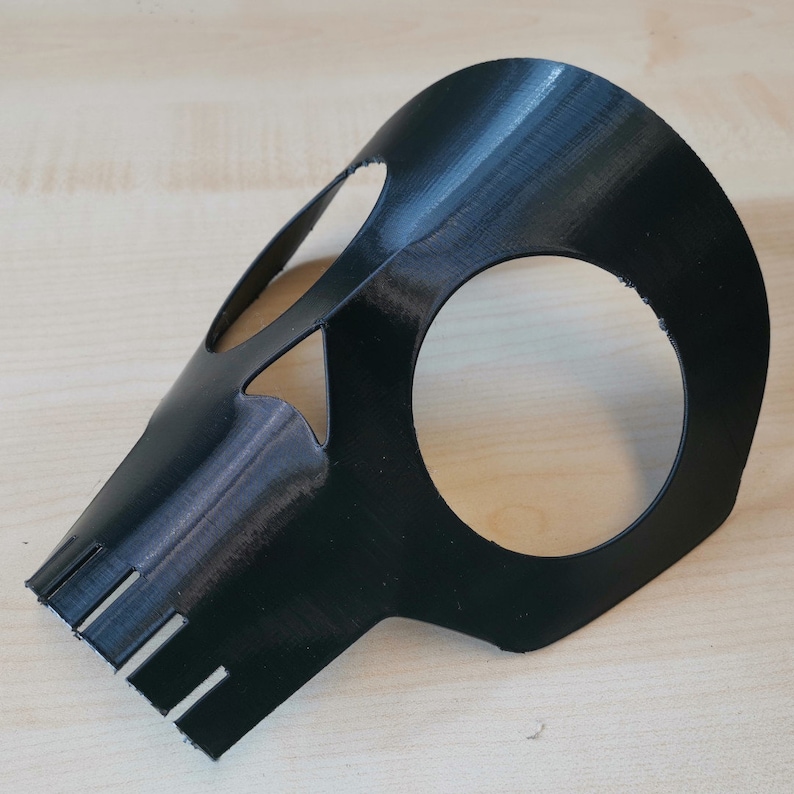 K&ouml;nnte beinhalten: Eine schwarze Plastik-Sch&auml;delmaske mit Augen- und Mundaussparungen. Die Maske ist so konzipiert, dass sie Augen und Nase bedeckt.
