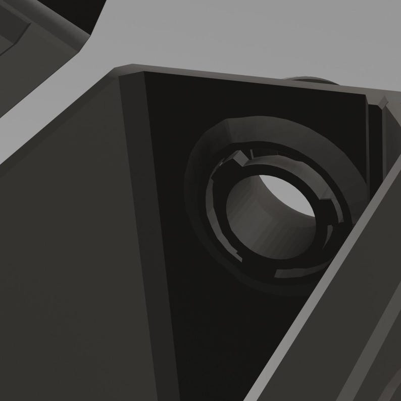 May include: A close-up of a black plastic part with a circular hole in the center. The hole is surrounded by a raised lip.