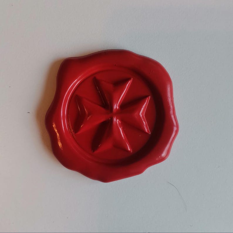 Puede incluir: Un sello de cera rojo con un dise&ntilde;o de cruz de Malta.