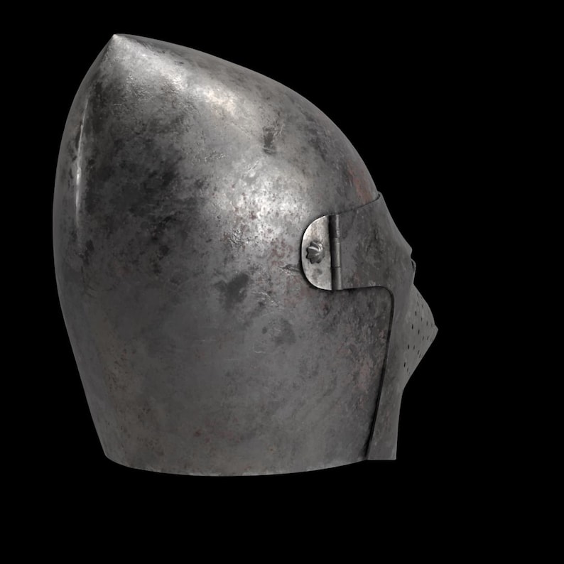 Pode incluir: Vista lateral de um capacete medieval de a&ccedil;o cinza fosco, com um topo pontiagudo e uma viseira articulada. A viseira tem pequenos orif&iacute;cios de ventila&ccedil;&atilde;o. O metal mostra sinais de desgaste.