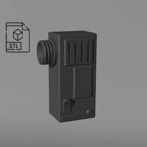 Puede incluir: Un objeto rectangular gris oscuro impreso en 3D con un accesorio cilíndrico en el lado izquierdo y una serie de barras verticales en la parte delantera. El objeto tiene un pequeño botón circular y un panel rectangular. Un icono de archivo STL está en la esquina superior izquierda.