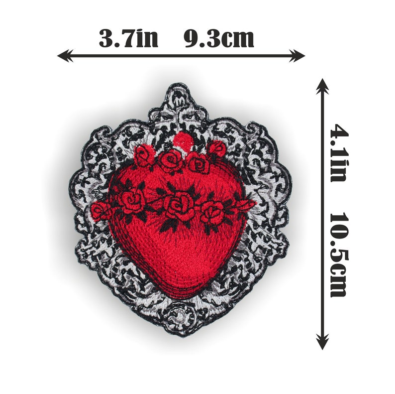 Puede incluir: Coraz&oacute;n rojo bordado con una corona de flores, rodeado de un marco adornado en negro y plata. El coraz&oacute;n mide 9,3 cm de ancho y 10,5 cm de alto.