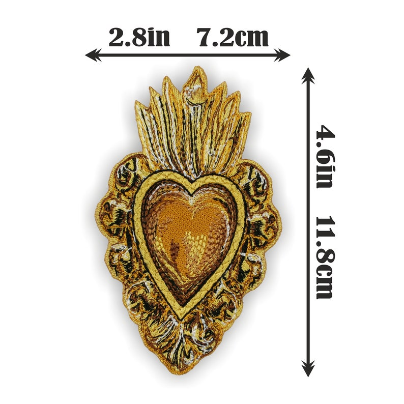 Puede incluir: Un parche de hierro bordado en oro de un coraz&oacute;n con llamas, que mide 11,8 cm por 7,2 cm.