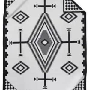 May include: A rectangular blanket featuring a white base with a large central diamond pattern in black and grey. The design includes geometric shapes, cross-like symbols, and a black border with a checkered pattern at the corners.