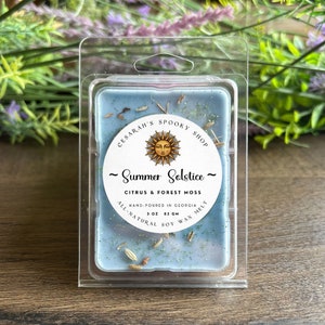 May include: A blue wax melt with a white label that reads "CESARAH'S SPOOKY SHOP ~ Summer Solstice ~ CITRUS & FOREST MOSS HAND-POURED IN GEORGIA 3 OZ 85 GM ALL-NATURAL SOY WAX MELT".