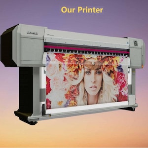 May include: A large format printer with a white body and a black control panel. The printer is printing a colorful image of a woman with flowers in her hair.