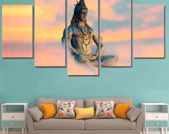 Puede incluir: Impresión en lienzo de varios paneles que representa una estatua serena de una deidad en una pose meditativa contra un fondo de un cielo de colores pastel. La estatua está detallada con joyas intrincadas y una expresión serena. La obra de arte se exhibe sobre un sofá gris con cojines coloridos.