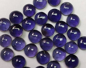 May include: A collection of round, purple amethyst cabochons. The cabochons are smooth and polished, with a slight sheen.