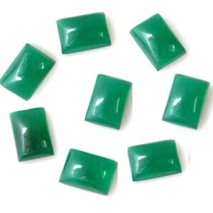 May include: Eight green rectangular cabochon gemstones. The gemstones are smooth and polished.
