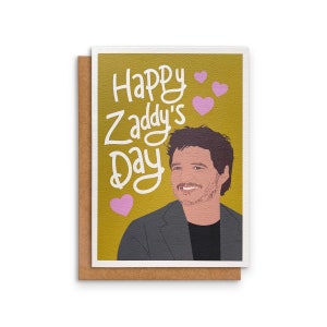 May include: A greeting card with a yellow background and the text "Happy Zaddy's Day" in white. The card features a cartoon illustration of a man with brown hair and a beard wearing a gray suit jacket. There are pink hearts scattered around the text.