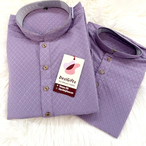 May include: Two lavender-colored, long-sleeved shirts with a textured diamond pattern. Each shirt has a mandarin collar and wooden buttons. A tag with the text "DesiGifts" is attached to one shirt.