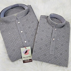 May include: Two gray embroidered shirts with a button-up collar and a decorative pattern. The shirts are made of a soft, lightweight fabric and have a relaxed fit. The tag on the shirt reads "DesiGifts - Fine with your traditions - Delaware, USA - https://desigiftsusa.com".