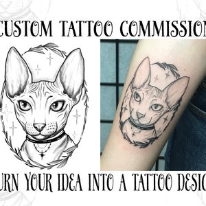 Op de afbeelding: Zwart-witte lijntekening tattoo-ontwerp van een Sphynx-kat met een choker met een kruisbedel. De kat is omringd door een krans van bladeren en sterren. Het ontwerp is te zien op de arm van een persoon.