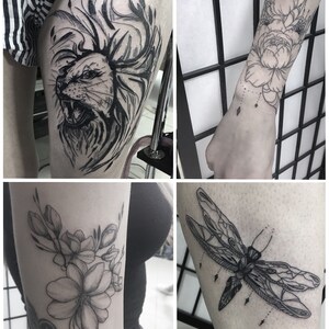 Op de afbeelding: Vier zwart-witte tatoeageontwerpen op de huid. De ontwerpen omvatten een leeuwenkop, een libel en twee bloemmotieven.