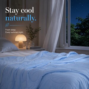 May include: A light blue quilted blanket covers a bed in a room at night. Text on the image reads: Stay cool naturally. Fresh sleep. Every summer night. A mushroom-shaped lamp, a glass, and a small plant are visible on a bedside table nearby.