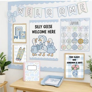 Puede incluir: Un tabl&oacute;n de anuncios de aula con un tema azul claro y blanco. Presenta una pancarta de "WELCOME", un calendario y varias impresiones enmarcadas. Las impresiones incluyen ilustraciones de gansos, cuadernos, l&aacute;pices y un jarr&oacute;n con flores. El texto "SILLY GEESE WELCOME HERE" es visible.