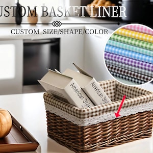 Può includere: Un cesto di vimini marrone con una fodera in tessuto a quadri vichy e un bordo in pizzo bianco. Il cesto è pieno di libri che dicono "American Style".  "CUSTOM BASKET LINER" e "CUSTOM SIZE/SHAPE/COLOR" sono scritti in nero nella parte superiore dell'immagine. Un mucchio di campioni di tessuto a quadri vichy in vari colori è mostrato nell'angolo in alto a destra dell'immagine.