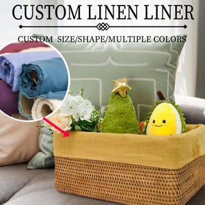 Puede incluir: Una cesta de mimbre con un forro de lino amarillo. La cesta está llena de varios artículos, incluyendo un árbol de Navidad de peluche verde, un fruto de durian de peluche amarillo y un ramo de flores blancas y rosas. El texto "CUSTOM LINEN LINER" y "CUSTOM SIZE/SHAPE/MULTIPLE COLORS" se muestra encima de la cesta.