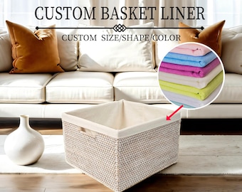 May include: A white wicker basket liner with a white fabric lining. The liner is sitting on a white rug in front of a white couch. The text "CUSTOM BASKET LINER" and "CUSTOM SIZE/SHAPE/COLOR" is displayed above the basket. A stack of colorful fabric swatches is shown in the upper right corner of the image.