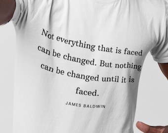 May include: White t-shirt with a quote by James Baldwin: "Not everything that is faced can be changed. But nothing can be changed until it is faced."