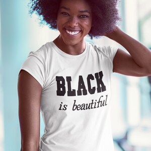 May include: A white t-shirt with the text "BLACK is beautiful" printed in black.