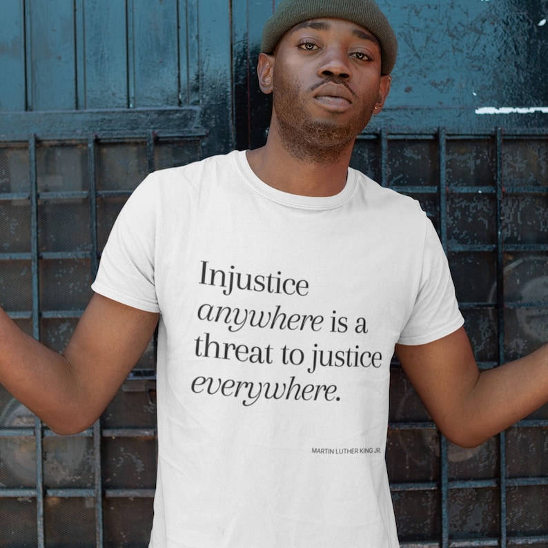 May include: White t-shirt with the quote "Injustice anywhere is a threat to justice everywhere." by Martin Luther King Jr.