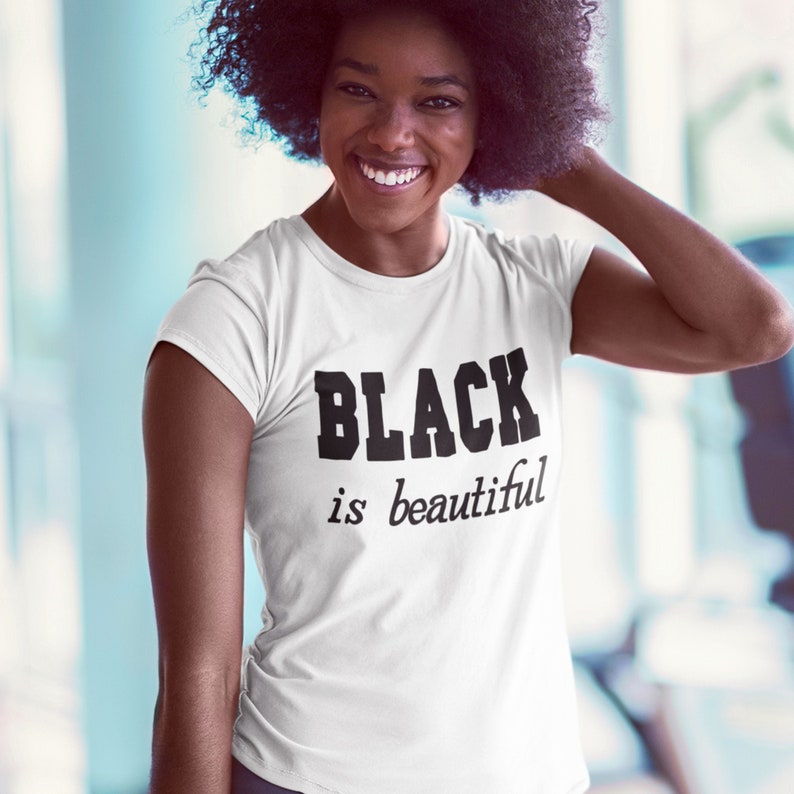 May include: A white t-shirt with the text "BLACK is beautiful" printed in black.