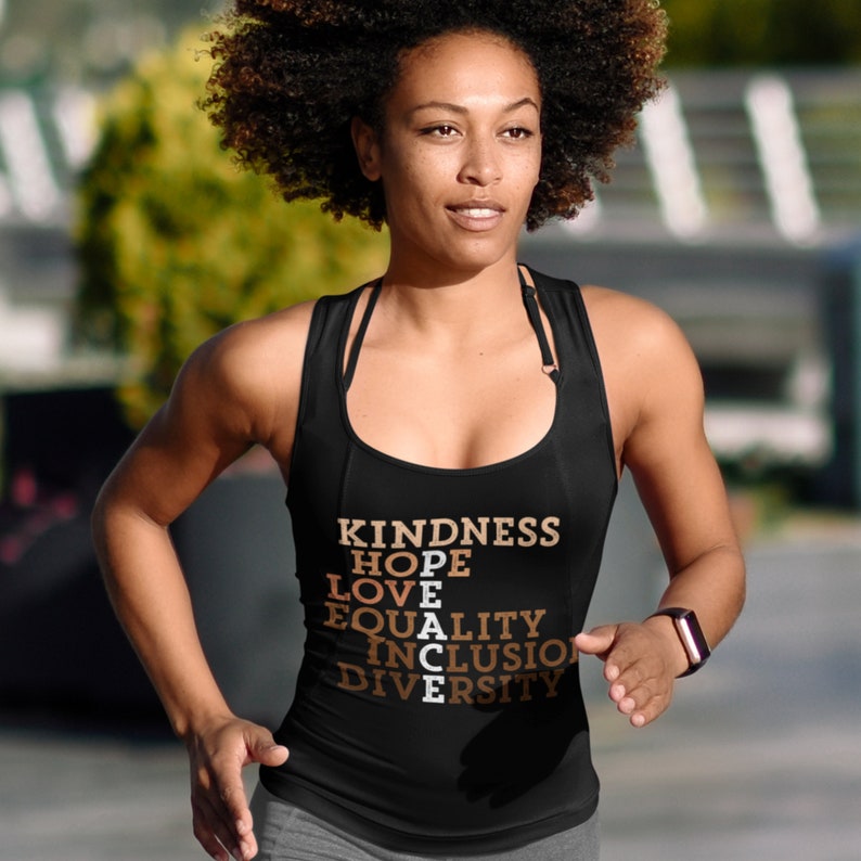 May include: A black tank top with the words "KINDNESS", "HOPE", "LOVE", "PEACE", "EQUALITY", "INCLUSION", and "DIVERSITY" printed in brown and orange letters.