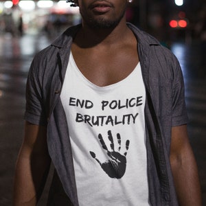 以下が含まれることがあります： 「END POLICE BRUTALITY」という文字と黒い手のひらのプリントがされた白いタンクトップ