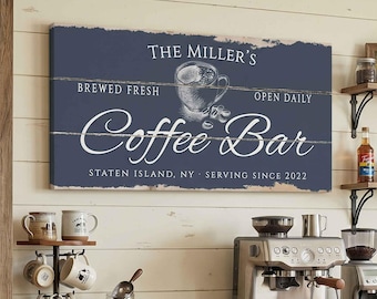 May include: A navy blue wooden sign that reads "The Miller's Coffee Bar" with a coffee cup illustration. The sign also includes the text "Brewed Fresh, Open Daily, Serving Since 2022, Staten Island, NY". The sign is mounted on a white wooden wall.
