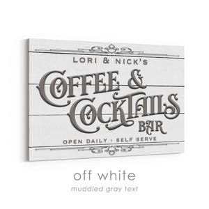 May include: Off-white wooden sign with the text "LORI & NICK'S COFFEE & COCKTAILS BAR" in muddled gray. The sign also includes the phrases "OPEN DAILY" and "SELF SERVE". Decorative flourishes are at the top and bottom.