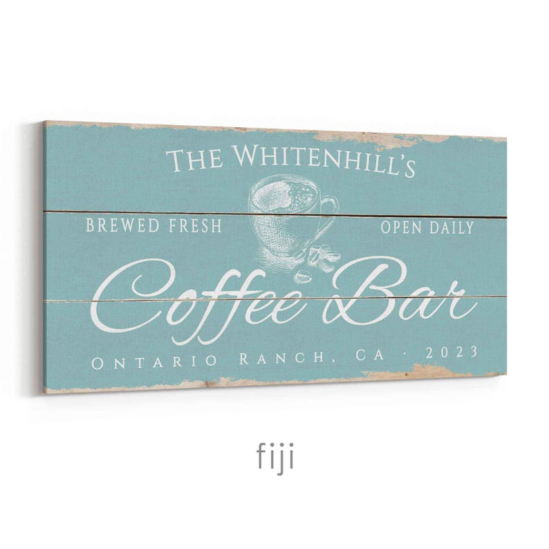 Pode incluir: Uma placa de madeira azul clara desgastada com as palavras "The Whitenhill's Coffee Bar" em escrita branca. A placa tamb&eacute;m inclui o texto "Brewed Fresh", "Open Daily" e "Ontario Ranch, CA 2023". Um gr&aacute;fico de x&iacute;cara de caf&eacute; est&aacute; no centro.