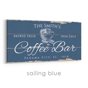 Pode incluir: Uma placa retangular de madeira azul marinho com texto branco que diz "The Smith's Coffee Bar" com uma ilustra&ccedil;&atilde;o de x&iacute;cara de caf&eacute;. O texto adicional inclui "Brewed Fresh", "Open Daily" e "Panama City, FL 1978".