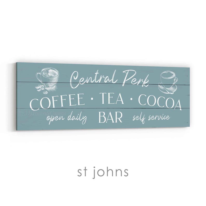 May include: A rectangular, teal wooden sign featuring white text and illustrations. The sign says "Central Perk" with the words "Coffee, Tea, Cocoa, Bar, self service, open daily". The sign has illustrations of coffee cups.