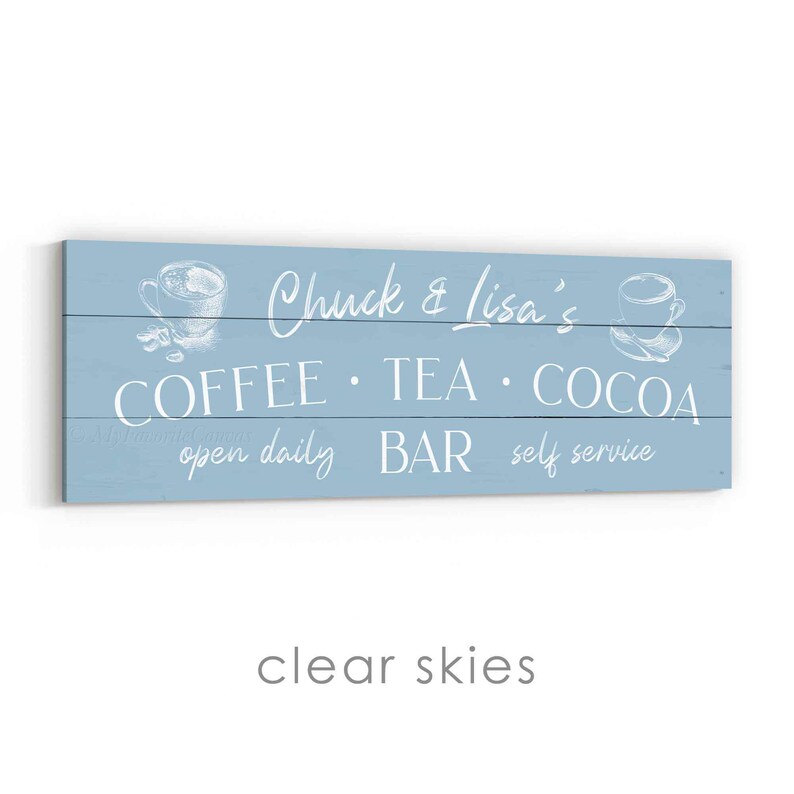 May include: A pale blue wooden sign with white lettering. It reads "Chuck & Lisa's COFFEE &bull; TEA &bull; COCOA BAR open daily self service." There are illustrations of coffee cups.