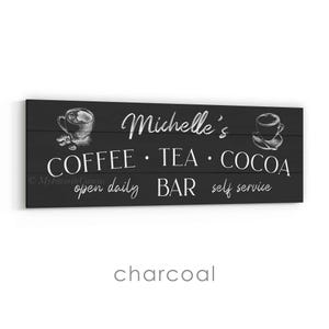 May include: A charcoal-coloured wooden sign with white text and illustrations. The sign reads "Michelle's COFFEE &bull; TEA &bull; COCOA BAR open daily self service" with coffee and tea cup illustrations.