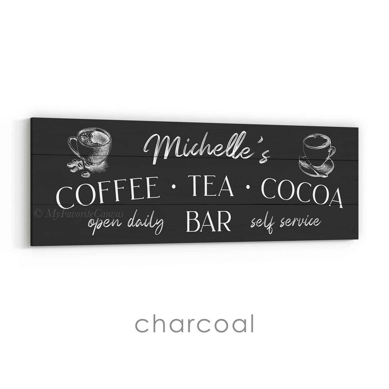 May include: A charcoal-coloured wooden sign with white text and illustrations. The sign reads "Michelle's COFFEE &bull; TEA &bull; COCOA BAR open daily self service" with coffee and tea cup illustrations.