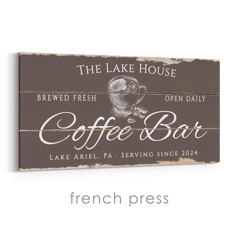 Pode incluir: Uma placa retangular de madeira com fundo marrom e texto branco. A placa diz "THE LAKE HOUSE", "BREWED FRESH", "OPEN DAILY" e "Coffee Bar". Uma ilustra&ccedil;&atilde;o de uma x&iacute;cara de caf&eacute; est&aacute; no centro. O texto "LAKE ARIEL, PA SERVING SINCE 2024" est&aacute; na parte inferior.
