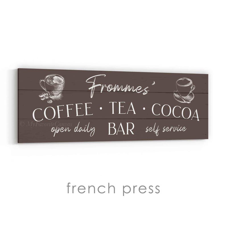 May include: A rectangular wooden sign with a dark brown background. The sign features white text and illustrations related to a coffee, tea, and cocoa bar. The text includes "Frommes'", "COFFEE &bull; TEA &bull; COCOA", "open daily BAR self service".