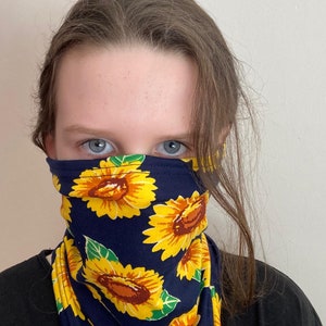 Pode incluir: Uma máscara facial azul com um padrão de girassol. A máscara é feita de um tecido macio e confortável e é perfeita para o uso diário.