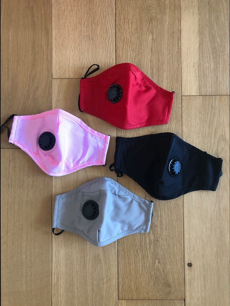 May include: Four reusable face masks with a valve. The masks are in red, pink, black, and grey.