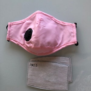 May include: Pink reusable face mask with a black valve and two white PM2.5 filters.