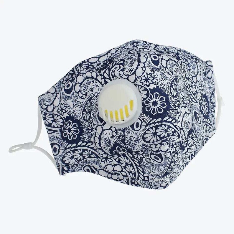 May include: A blue and white paisley patterned face mask with a white valve. The mask has elastic ear loops.
